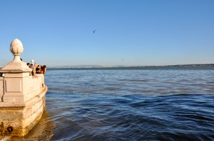 All those people are looking at that stuff in the water. 'That stuff' is actually fish. Look at the number of them!